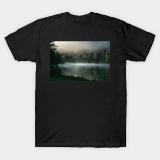 Magic Misty Lake. Amazing shot of a wooden house in the Ferchensee lake in Bavaria, Germany, in front of a mountain belonging to the Alps. Scenic foggy morning scenery at sunrise. T-Shirt